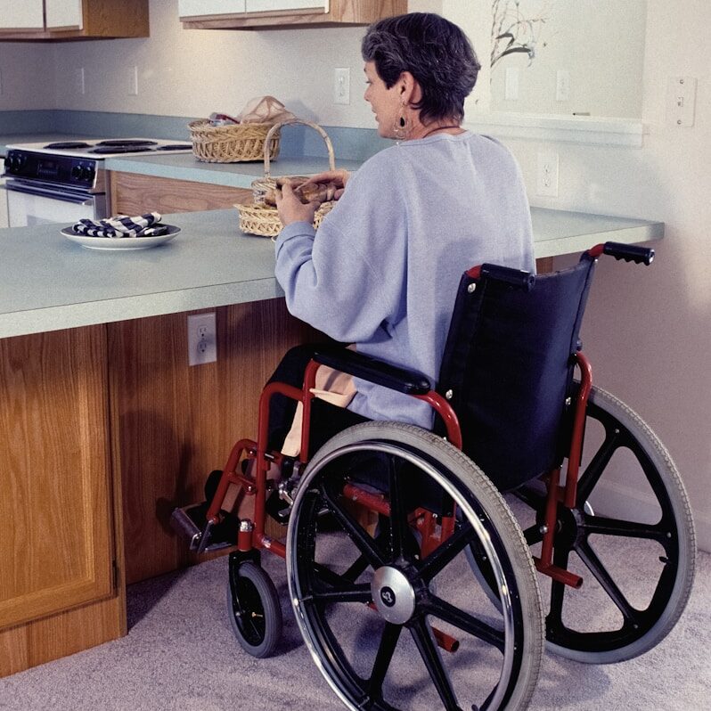 a woman in a wheel chair in a kitchen